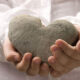 Dječje ruke drže kameno srce, predaju ga drugome