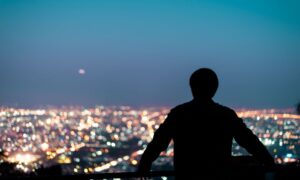 Muškarac promatra svjetla grada tijekom noći