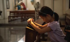 Djevojčica se moli u crkvi