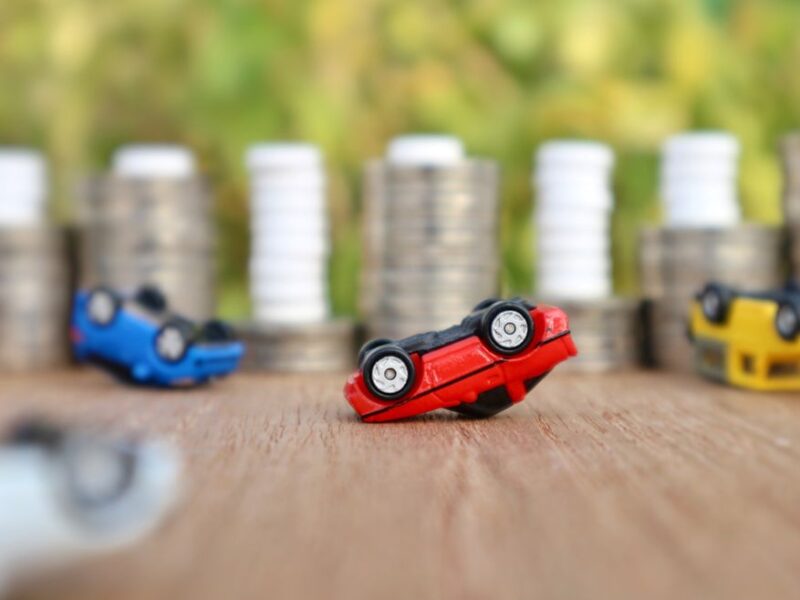 Car,Debt,And,Stres,Concept,,Miniature,Red,Car,Overturned,Upside