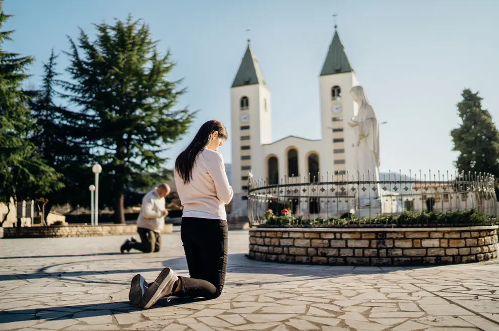 Žena kleči u molitvi u Međugorju