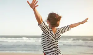 Žena na plaži, osjeća se slobodno
