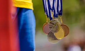 Osoba drži olimpijske medalje u ruci