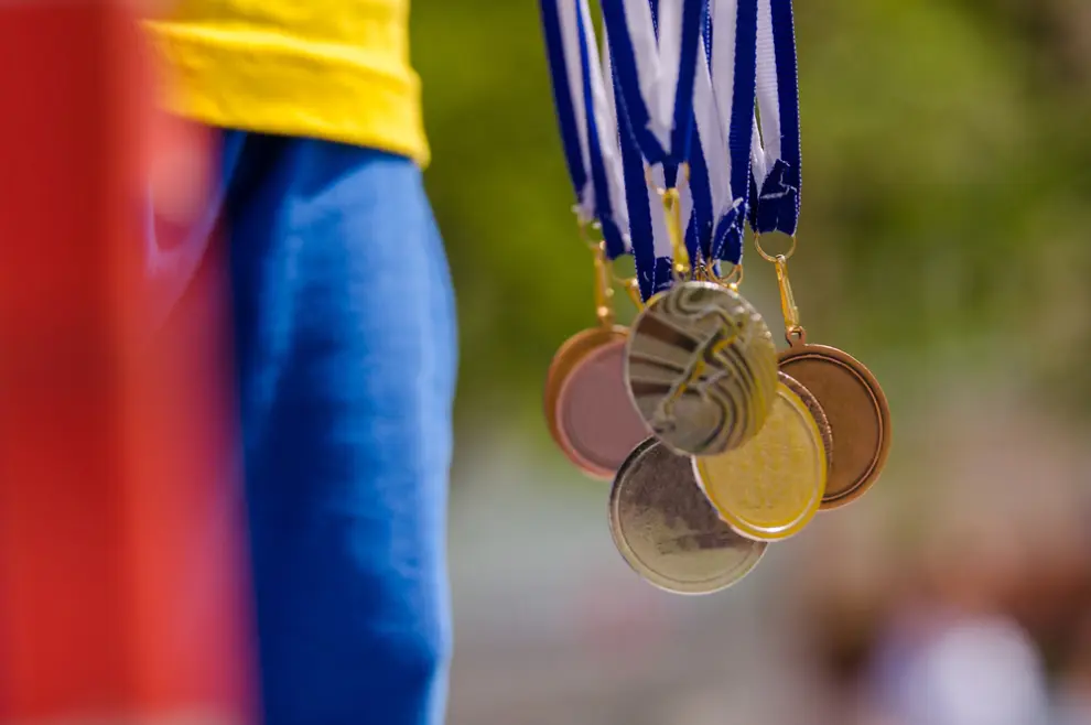 Osoba drži olimpijske medalje u ruci