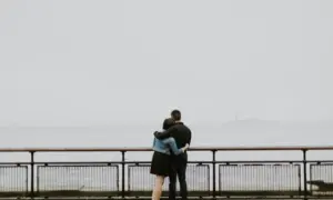Par zagrljen,gleda u rijeku u magli