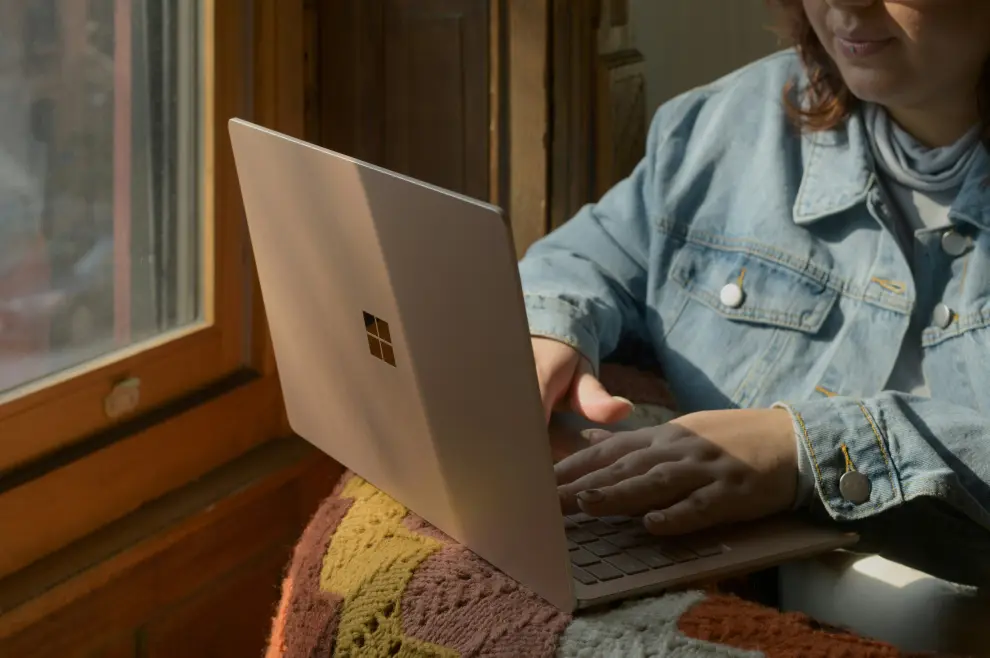 Žena drži laptop na krilu, elektronika